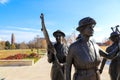 A shot of the copper statues at the Tennessee Woman`s Suffrage Monument with blue sky and clouds surrounded by autumn colored tree