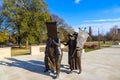 A shot of the copper statues at the Tennessee Woman`s Suffrage Monument with blue sky and clouds surrounded by autumn colored tree