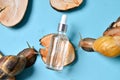 Cosmetic serum with extract of snail slime and a snails on a wood. snail mucus extract