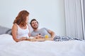 Starting the day with food and love. Shot of a couple enjoying breakfast in bed together at home. Royalty Free Stock Photo