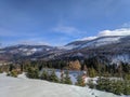 Shot of cozy countryside cottages, scenic nature in winter with snowy mountains in the background Royalty Free Stock Photo