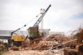 Its dirty work. Shot of a crane at work in a dumpsite. Royalty Free Stock Photo