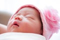 A shot of a cute baby girl newborn with flower pink hat while sleeping / Focus at infant girl