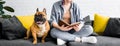 Shot of cute bulldog sitting on sofa with girl, who reading book Royalty Free Stock Photo