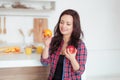 Shot of a dark haired caucasian woman comparing apples to oranges Royalty Free Stock Photo