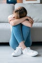 Depresive young woman thinking about her problems while sitting on the floor in the living room at home Royalty Free Stock Photo