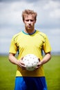 I wont settle for less than a win. Shot of a determined looking soccer player holding a soccer ball outdoors.