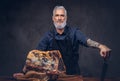 Old butcher cutting huge meat piece on wooden table