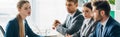 Shot of employee sitting at table near recruiters in office