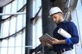 Shot of a engineer using a digital tablet on a construction site. This software help me to keep track of everything