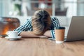 Exhausted young business woman who has fallen asleep while working wirh laptop in living room at home Royalty Free Stock Photo