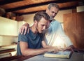 Theyre a family made stronger in faith. Shot of a father and son doing Bible study together at home. Royalty Free Stock Photo