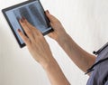 Shot of the female doctor in uniform against the white wall studying x-ray image of the lungs on the tablet. Healthcare Royalty Free Stock Photo