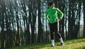 Shot of fitness young runner man standing outside in park after jogging. Confident athletic young man ready of workout. People and