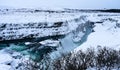 Shot of a freezing river with cascade falling into a gorge on winter Royalty Free Stock Photo