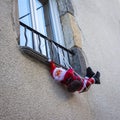 Shot of funny Santa Clause hanging on a balcony Royalty Free Stock Photo