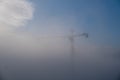 Shot of a giant crane in the sky appearing through the clouds