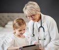 How are you feeling today. Shot of a girl and a doctor using a tablet at home. Royalty Free Stock Photo