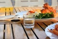 A shot glass of cold vodka and snacks on a wooden table, close-up Royalty Free Stock Photo