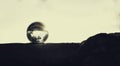 Shot of a glass sphere reflecting its surroundings within itself, placed on the ground Royalty Free Stock Photo