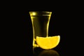 Shot glass of vodka with lemon slice on dark background Royalty Free Stock Photo