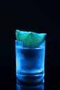 Shot glass of vodka with lime slice on dark background Royalty Free Stock Photo