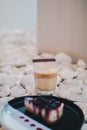 Shot glasses with homemade coffee and blueberry cheese pie on Small stones white and black Royalty Free Stock Photo