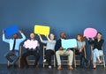 It feels good being able to speak your mind. Shot of a group of people holding up speech bubbles against a blue