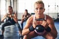 Burning fat and building muscles. Shot of a group of people lifting weights at the gym. Royalty Free Stock Photo