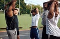 Got to warm up before we shoot some hoops. Shot of a group of sporty young men stretching their arms on a sports court.