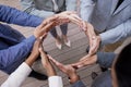 Moving together. Shot of a group of unrecognizable businesspeople forming a circle with their hands outside.