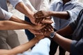 Were in this together. Shot of a group of unrecognizable businesspeople stacking their hands at work.