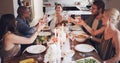 Gather your friends and let the good times flow. Shot of a group of young friends toasting with wine at a Christmas Royalty Free Stock Photo