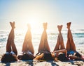 Long, lazy, beachy days. Shot of a group of young women relaxing together with their legs up at the beach.