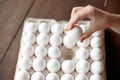 Shot of hand of man picking up one fresh chicken egg from full egg tray in farmers market stall Royalty Free Stock Photo