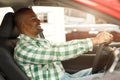 Handsome African man choosing new car at dealership Royalty Free Stock Photo