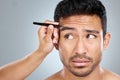 They just need a little shaping. Shot of a handsome man getting his eyebrows tweezed. Royalty Free Stock Photo