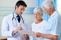 Thats completely within normal range. Shot of a handsome young doctor explaining results to a senior couple. Royalty Free Stock Photo