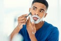 What a good time for the weekly shave. Shot of handsome young man beginning to shave his face. Royalty Free Stock Photo