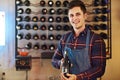 This one will hit the spot and your pocket. Shot of a handsome young man choosing a bottle of wine in a restaurant. Royalty Free Stock Photo