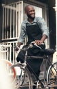 Im the citys best bike salesman. Shot of a handsome young man moving a bicycle from his shop during the day.