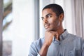 Hes got a lot on his mind. Shot of a handsome young man thinking while looking through the window. Royalty Free Stock Photo