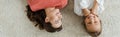 Shot of happy babysitter looking at kid lying on carpet