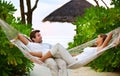 Relaxation and romance - VacationsGetaways. Shot of a happy couple relaxing on a hammock together in their own private Royalty Free Stock Photo