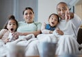 More than love. Shot of a happy family eating popcorn while watching television together at home. Royalty Free Stock Photo