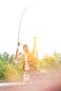 Shot of happy father catching fish at lakeshore