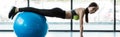 Shot of happy girl doing plank exercise on blue fitness ball in gym Royalty Free Stock Photo