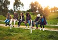 Getting out of the city for the weekend. Shot of a happy group of friends sitting in a row on a fence together. Royalty Free Stock Photo