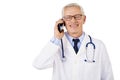 Happy male doctor portrait while making a call and standing at isolated background Royalty Free Stock Photo