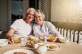 We still start our mornings together. Shot of a happy senior couple having a leisurely breakfast on the patio at home. Royalty Free Stock Photo